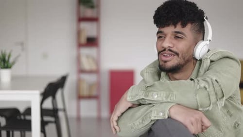 Handsome Young Adult Listening Indoors with Headphones