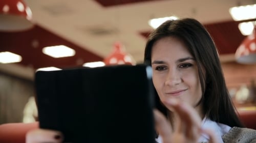 Woman Using Tablet Computer Touchscreen In Cafe
