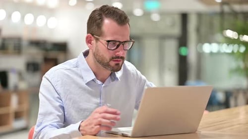 Loss Businessman Reacting to Failure on Laptop in Office