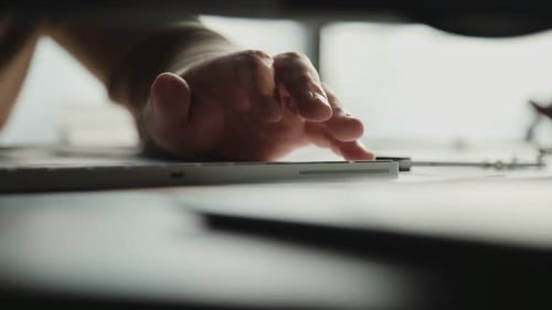 Men's Hands in a Beige Sweater Print on the Keyboard in Light Office