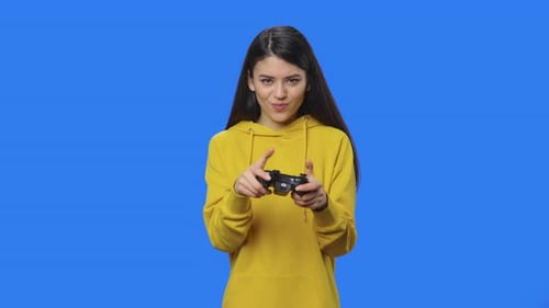 Young Woman Playing Video Games on Blue Background