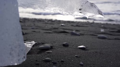 Block of ice melting on seashore