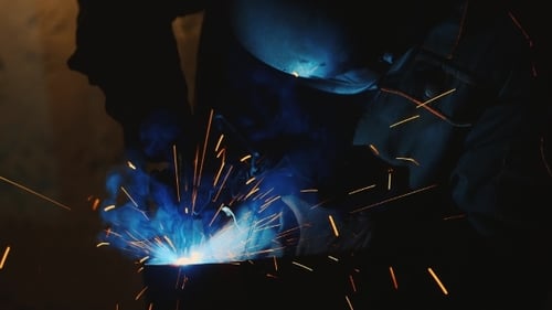 Schweißer bei der Arbeit. Viele spektakuläre Funken und geschmolzene