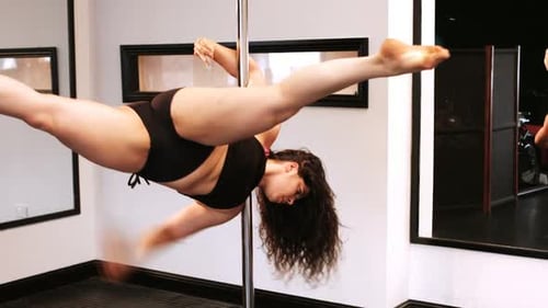 Woman Performing Pole Dance in Fitness Studio