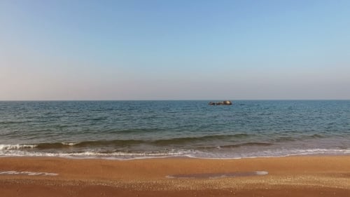 Fliegen über dem Meer mit Fels- und Sandküste