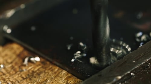 Drill Making a Hole in a Metal Plate