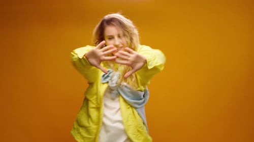 Woman Professional Dancer Dancing in Studio Against Yellow Background
