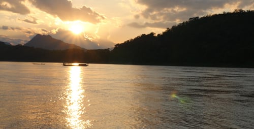Sunset In The River With Silhouette Boat