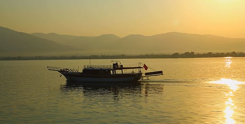 Motorboat Sailing on Calm Water at Sunrise