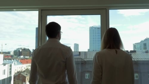 Man and Woman Looking Out at City Skyline