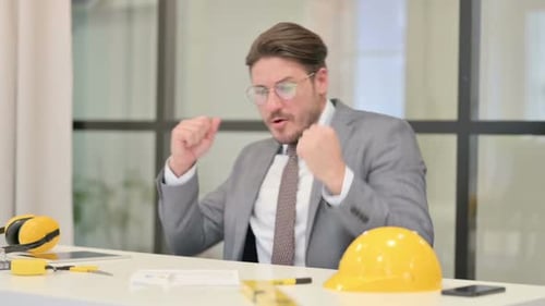 Happy Middle Aged Engineer Dancing while Celebrating in Office
