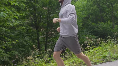 Man Running Through Forest on a Sunny Day