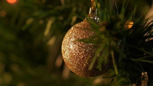 Shimmering Gold Christmas Ball on Green Tree