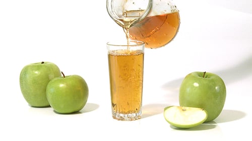 Pouring Fresh Apple Juice Into a Glass