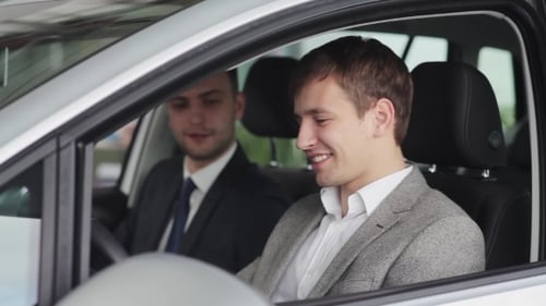 Men Discuss Car Purchase in Dealership Showroom