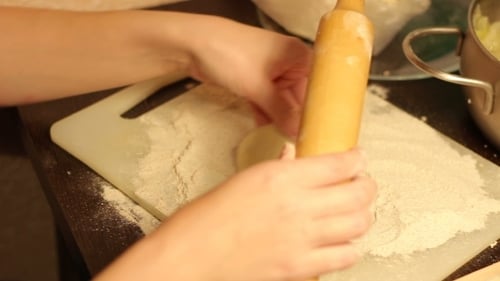 Woman Making Dough with Rolling Pin at Home