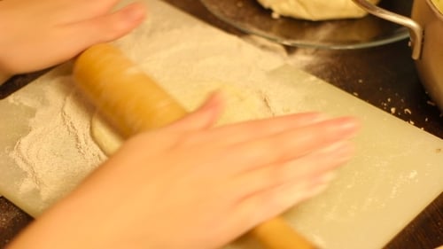 Close up of Hands Rolling Dough with Pin