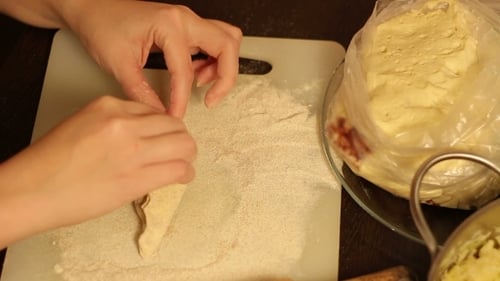 Hands Shaping Dough on Cutting Board in Kitchen