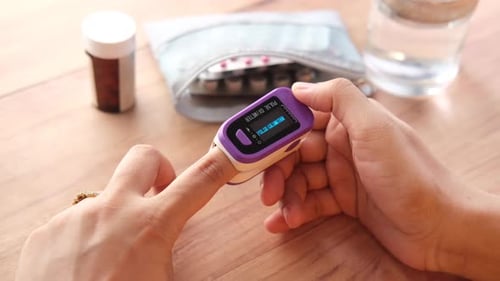 Person Checking Oxygen Level with Pulse Oximeter