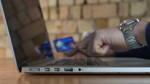 Hand Typing on Laptop Keyboard with Credit Card