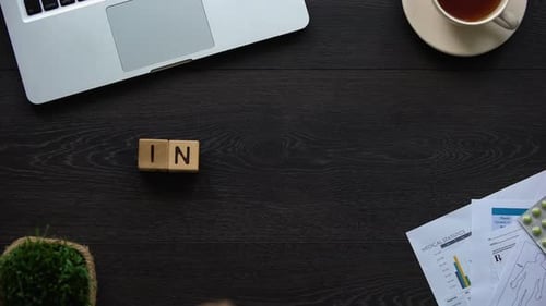 Hand Spells Out Insurance on Desk with Medical Items