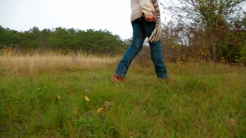 Woman Walking in Autumn Nature with Book