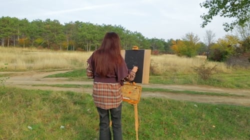 Woman Painting on Easel in Field Landscape