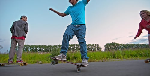 Friends Skateboarding Down a Rural Road