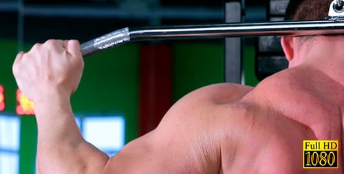 Muscular Man Working Out on Weight Machine in Gym