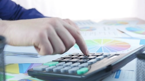 Hombre de negocios usando calculadora y análisis gráfico