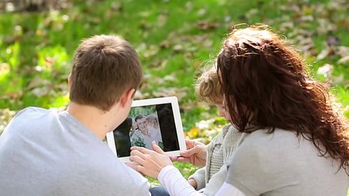 Family Using Tablet PC In Autumn Park