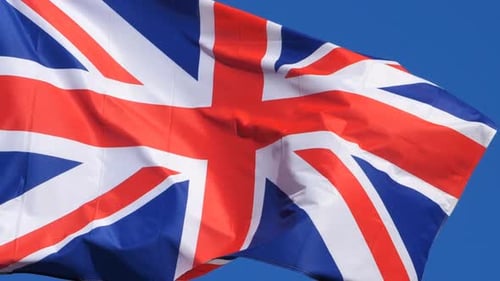 Union Jack Flag Waving Against Blue Sky