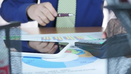 Adult at Work Using Calculator and Tablet