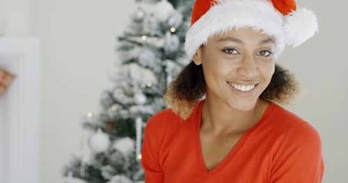 Smiling Woman in Santa Hat near Christmas Tree