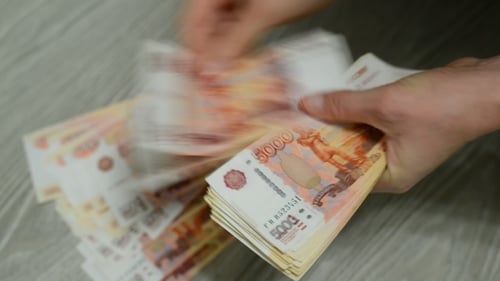 Mains de femmes comptant les billets russes.