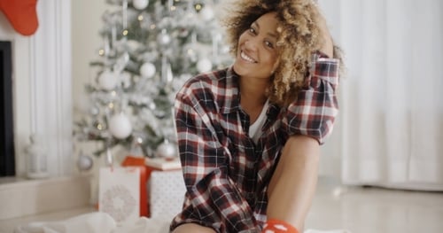 Smiling Woman in Plaid Shirt Next to Christmas Tree