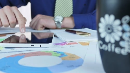 Geschäftsmann schreibt und trinkt Kaffee im Büro