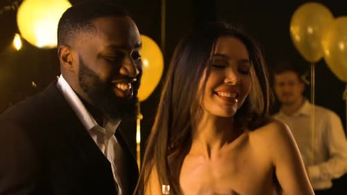 Smiling Multiracial Friends Dancing at Night Club Party Under Falling Confetti