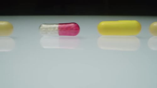 Macro Shot of Medicine Pills in Row on White Table