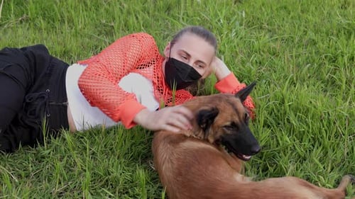 Young Woman Lying in Grass with Dog