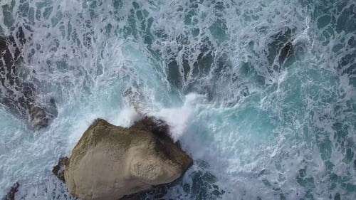 Aerial View of Crashing Waves on Rocks