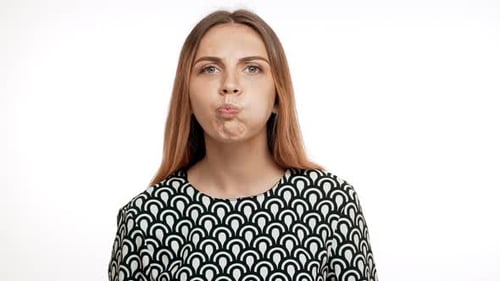 Young Beautiful Blonde Girl Showing Tongue Over White Background