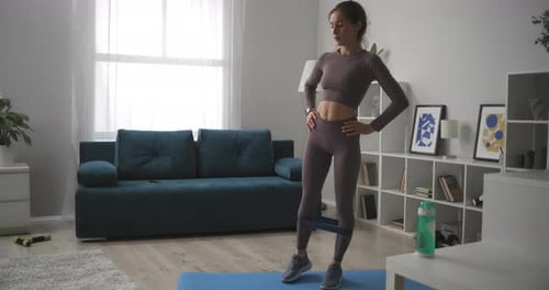 Woman Exercising with Resistance Band at Home