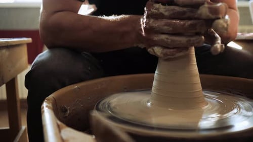 Un jeune potier travaille sur un tour de potier avec de l'argile