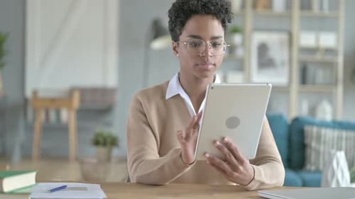 Young Adult Using Tablet at Desk Indoors