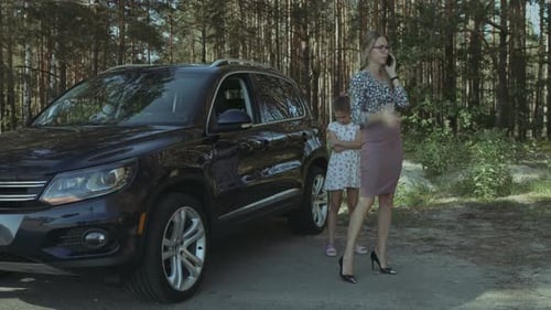 Woman and Daughter Near Car in Rural Wooded Area