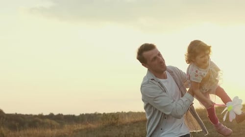 Familienurlaub in der Natur. Papa dreht seine Tochter in seinen Armen, als würde sie fliegen.