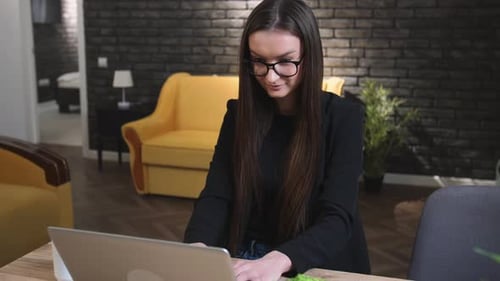 Young Woman Working on Laptop in Home Office