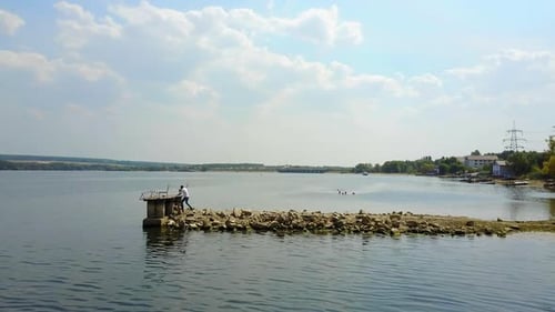 Man Taking Photos Near Pond. Photographer photographing landscape near river