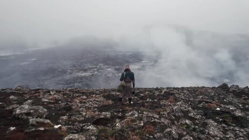 Adult Walking on Rocky Landscape on Foggy Day